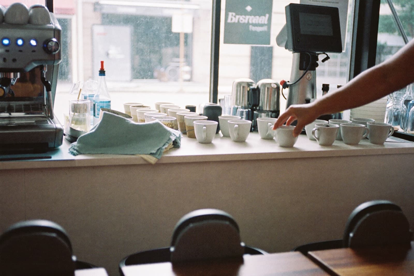 Cups being arranged on a cafe counter in morning light